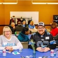 A family poses for a group photo at a table during the tailgate party